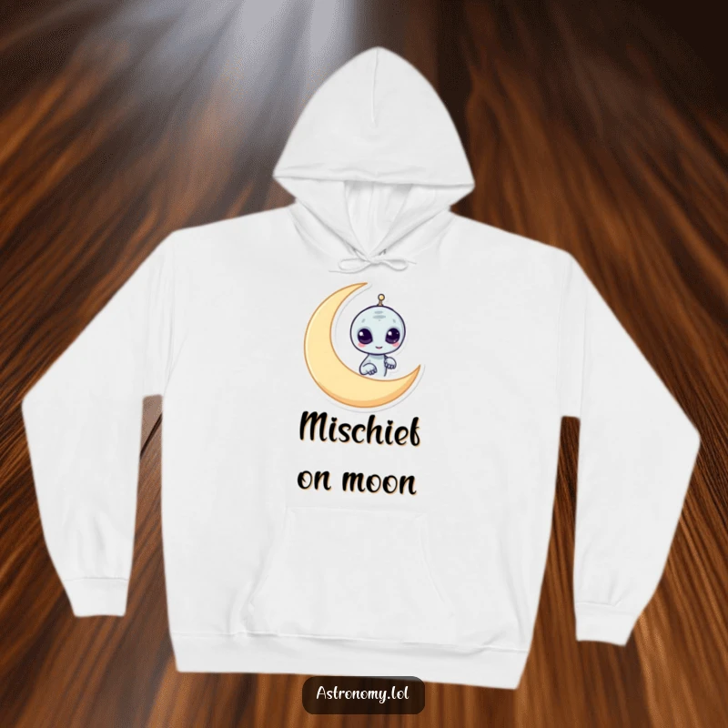 Funny alien hoodie featuring a mischievous character peeking from behind a crescent moon, offering warmth and playful humor.