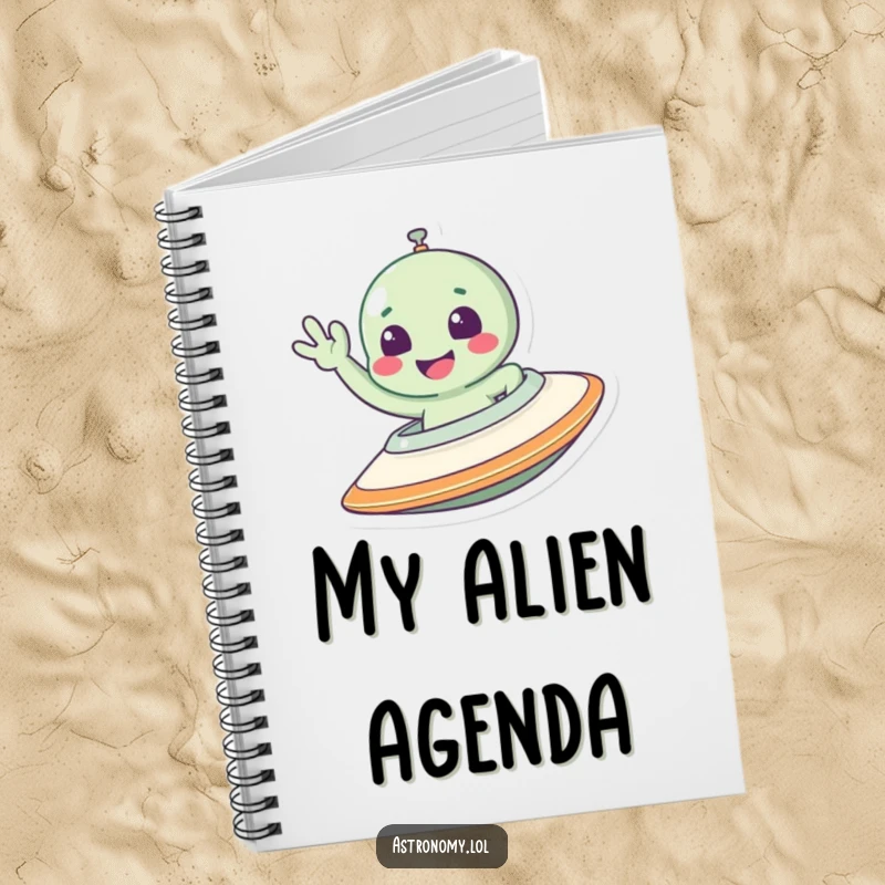 Funny alien notebook with a smiling character waving from a spaceship, perfect for jotting down cosmic ideas.