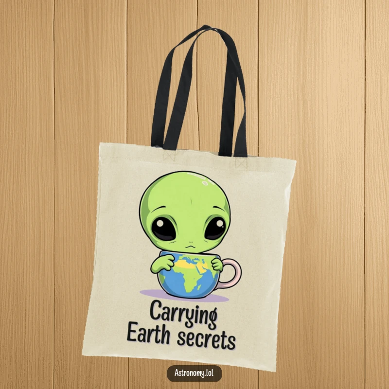 Funny alien tote bag featuring a confused three-eyed creature staring at an Earth mug, a humorous and practical accessory.