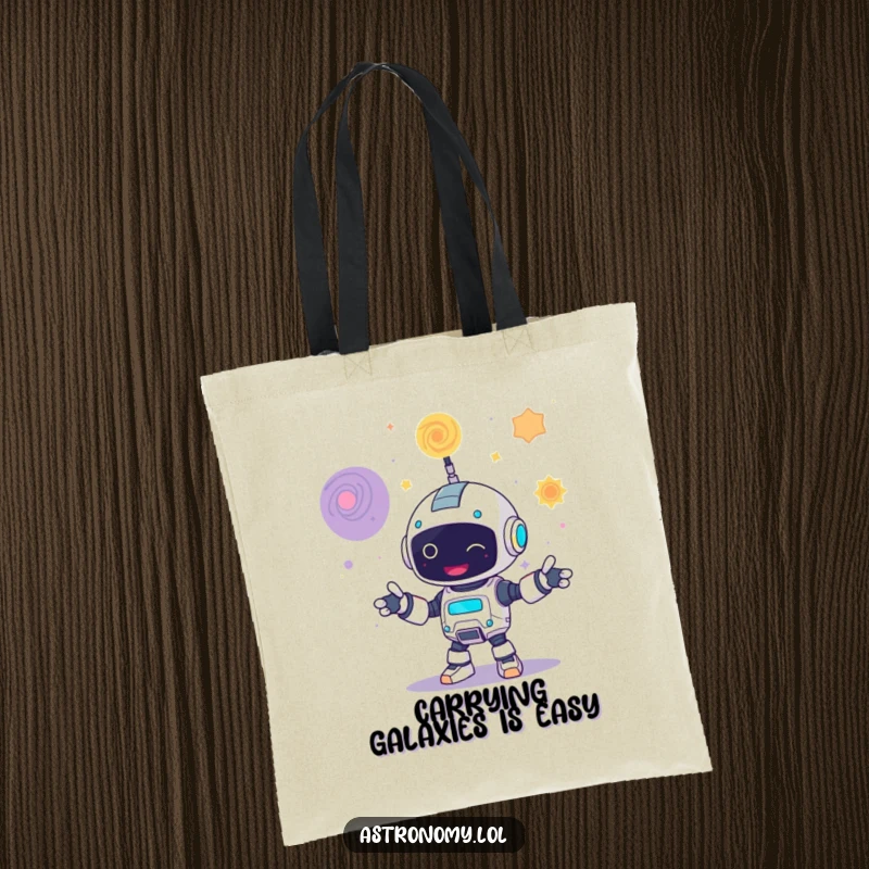 Funny tote bag showcasing a cheerful robot juggling three colorful galaxies, practical for carrying essentials with humor.
